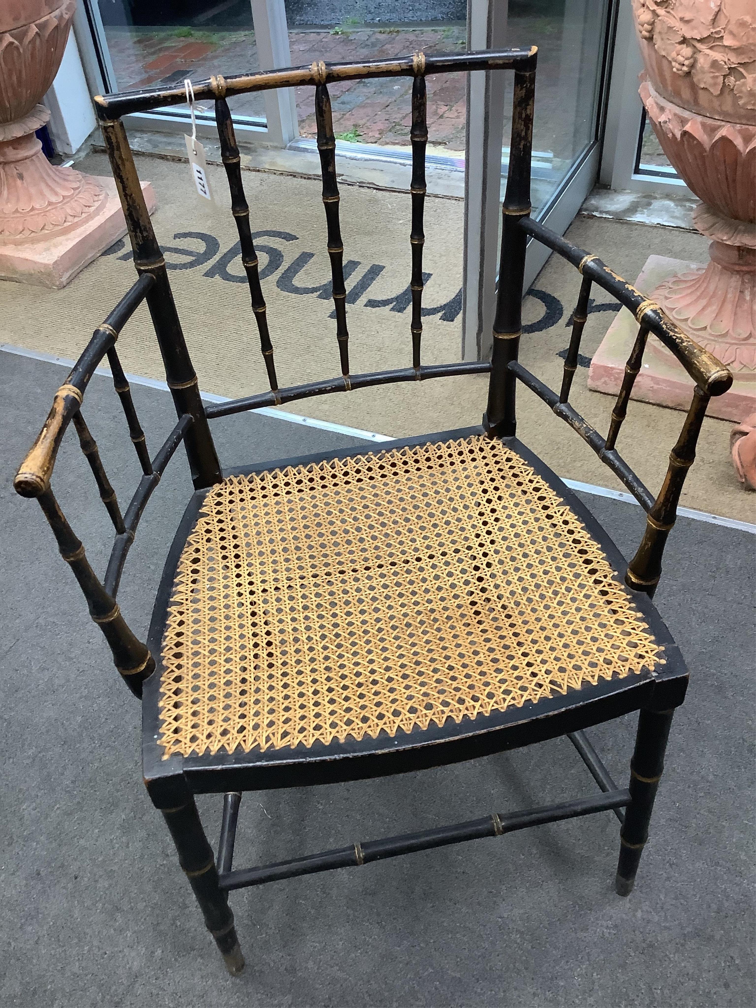 A set of four Regency ebonised simulated bamboo cane seat elbow chairs, width 56cm, depth 43cm, height 86cm. Condition - fair (one stretcher detached but present)